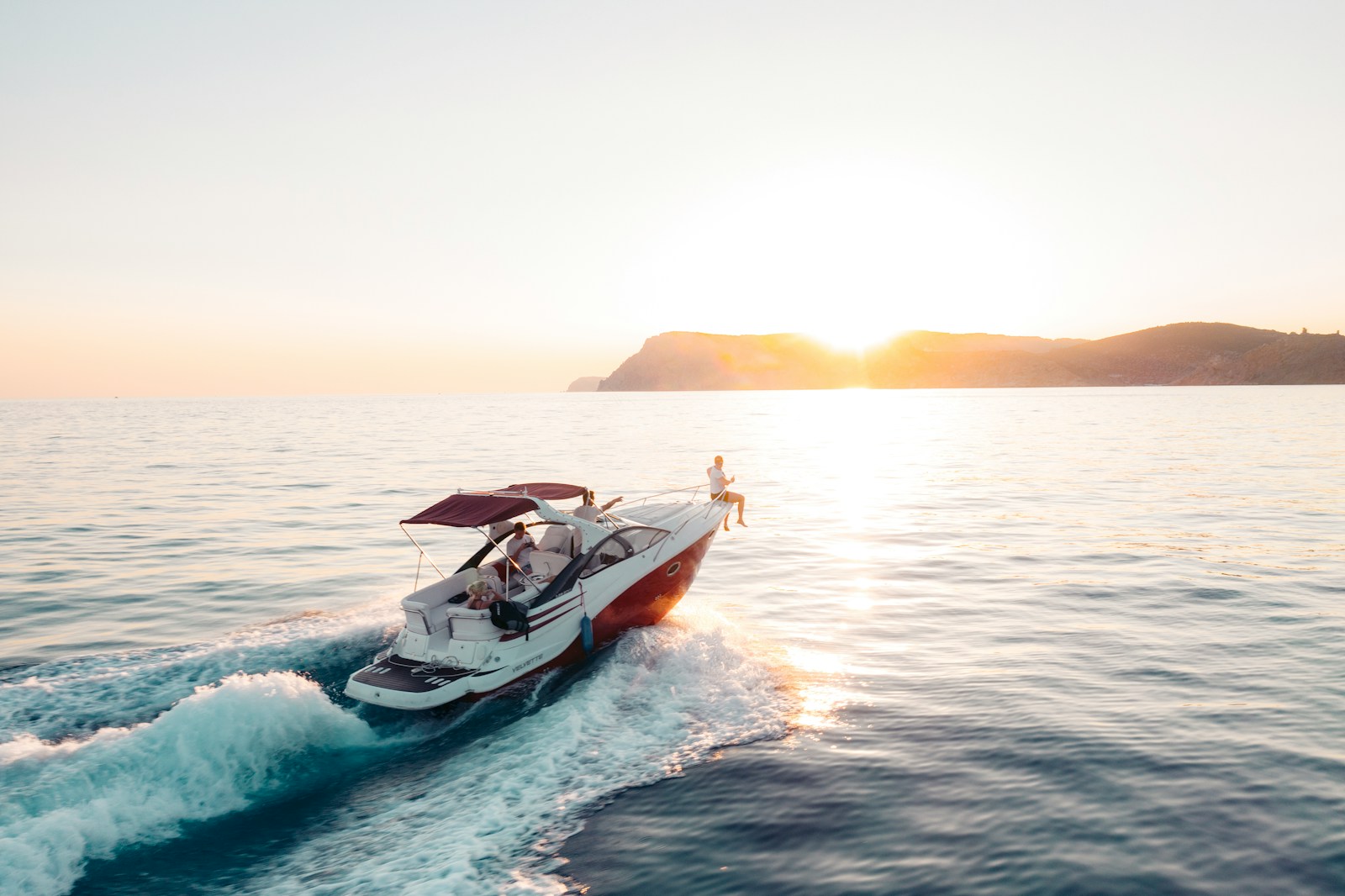 man riding on white and red boat on sea during daytime, watercraft